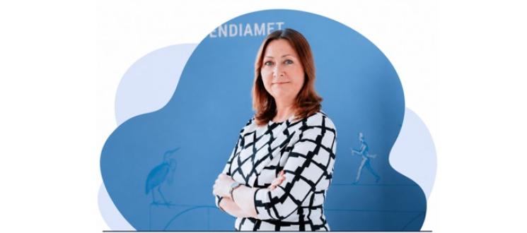 Musta-valge ruudulise kleidi ja tumedate pikkade juustega naine seisab käed vaheliti rinnal